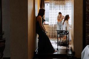 A hairdresser does a girl's hair at home. The bride is preparing for the wedding. Morning of the bride. photo