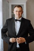 retrato de un joven novio a hogar antes de el Boda ceremonia. un hermoso hombre vestido en un clásico traje. masculino retrato. foto