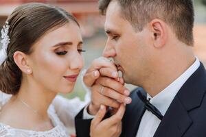 Wedding kiss. Groom kisses bride's hand. Weddng love. Close-up of a young man kissing his wife's hand with gold ring while making a marriage proposal. photo