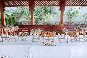 open-air buffet table, sandwiches on skewers before the start of the holiday against the background of flowering trees in the garden photo