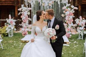 A handsome groom and an elegant bride in a lush white dress are walking in a summer park. Happy bride and groom getting ready for their best day. photo