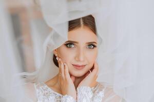 retrato de el novia en el hotel habitación. un hermosa joven niña es vestido en un blanco Boda vestido. moderno Boda peinado. natural constituir. foto