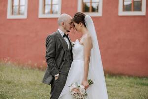 Close-up photo of a wedding couple looking each other in the eyes in nature. The bride and groom look each other in the middle of nature. Tenderness and love in the eyes.