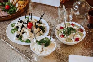 carne y queso meriendas en el bufé. un buffet en un cerrado habitación, a un Boda celebracion o cumpleaños. emparedados en brochetas antes de el comienzo de el día festivo. foto