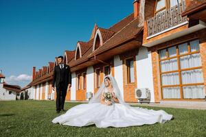 The bride is dressed in an elegant lush white wedding dress with a long veil and is ready for her groom. The first meeting of the bride and groom photo