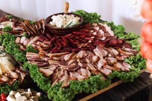 Meat and cheese snacks on the buffet. A buffet in a closed room, at a wedding celebration or birthday. Sandwiches on skewers before the start of the holiday. photo