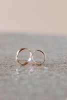 Gold wedding rings in a macro shot. Blurred background. Details. Elegant wedding rings for the bride and groom with highlights, selective focus photo