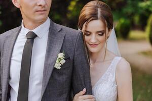 The bride is dressed in an elegant lush white wedding dress with a long veil and is ready for her groom. The first meeting of the bride and groom photo