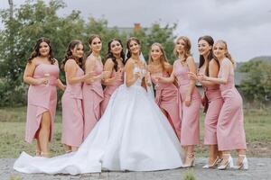 A beautiful bride and her bridesmaids are having fun in the morning. Wedding celebration. Happy girls at their best friend's wedding. A beautiful and elegant bride with her bridesmaids photo