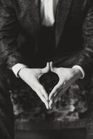 The hands of the man, the groom in a suit is sitting on the sofa and is ready for the first meeting. Black and white photo. photo