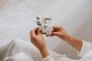 wedding boutonniere of flowers in the hands of the bride. Wedding details. The first meeting of the bride and groom. The bride is waiting for the groom. photo