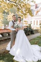 Happy couple celebrating their wedding outdoors. Amazing smiling wedding couple. Pretty bride and stylish groom. Wedding portrait. photo