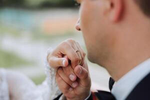 She told him yes. Close-up of a young man kissing his wife's hand with gold ring while making a marriage proposal. Engagement of a young couple in love. The concept of love and togetherness photo