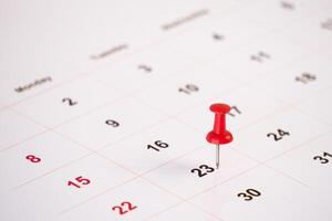 close up of a calendar with red push pin photo