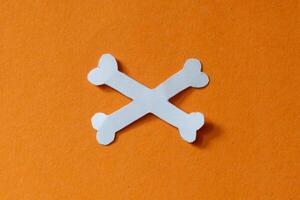 white cross bone in orange background photo