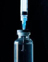 vacuna viales y médico jeringas en negro foto