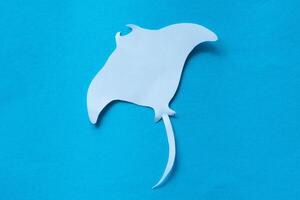 mantarraya cortar fuera papel en azul foto