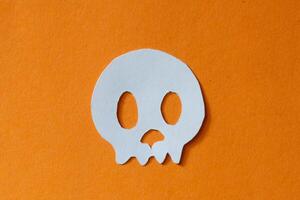 skull cut out paper on orange background photo