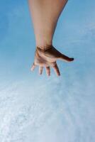 man hand gesturing and reaching the blue sky photo