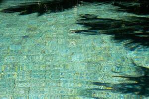agua superficie en nadando piscina con soleado reflexiones y oscuridad. foto