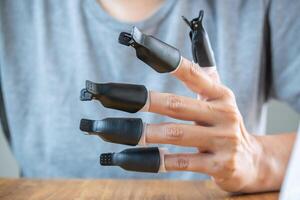 Hand of a young woman using presses to remove semi-permanent nail paint. photo