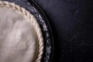 Detail of the closing of a vegetable tart, on a tray. photo