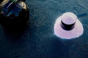 Scoop of creatine on a black table accompanied by a kettlebell. photo