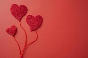 Concept of hearts with threads as if they were balloons on a red background. photo