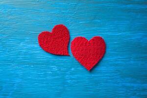 Plush red hearts on a textured light blue table. photo