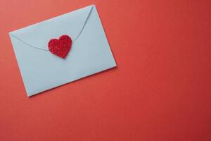 blanco tarjeta con un corazón de cerca en un rojo antecedentes con Copiar espacio. foto