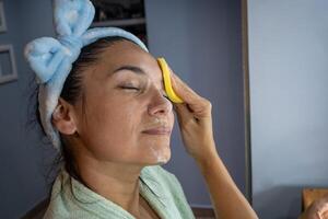 Latin girl cleans her face before going to sleep. photo