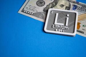 litio concepto con un cien dólar cuenta en un ligero azul antecedentes. foto