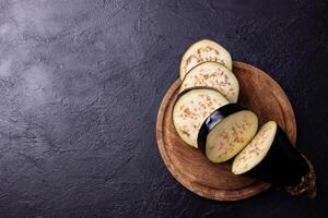 Eggplant cut into slices on a cutting board. photo