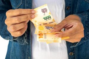 Argentine woman's hands counting Argentine pesos. photo