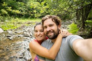 joven argentino Pareja tomando un selfie en un natural paisaje. foto