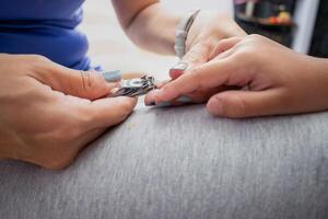 Mother cutting her daughter's nails photo