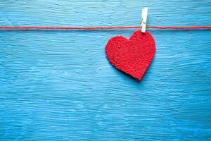 Heart hanging with a clothespin, on a light blue background. photo