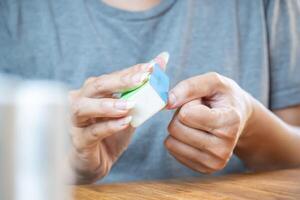 Woman's hands using a nail sponge that has different types of file. photo