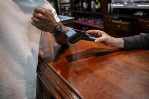 afroamericano hombre paga por el reloj en un restaurante foto