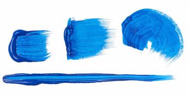 Various strokes of blue oil paint on a white background photo