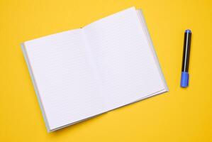 Open notebook with blank white sheets on a yellow background photo