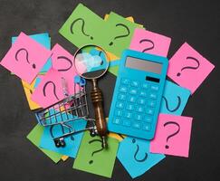 Drawn question marks on stickers and a magnifying glass, yellow background. photo