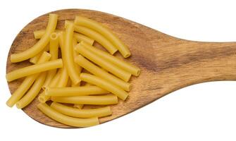 Tube-shaped pasta made from white wheat flour in a wooden spoon photo