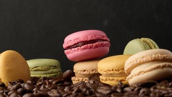 Stack of multi-colored macarons on a background of coffee beans, black background photo