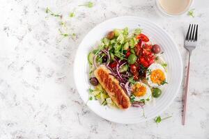 Breakfast homemade chicken sausage with boiled egg and fresh salad. Keto, ketogenic breakfast. Trendy breakfast. Top view, flat lay photo