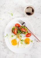 Keto breakfast. Fried eggs and toast with guacamole and tomatoes. Top view, flat lay photo