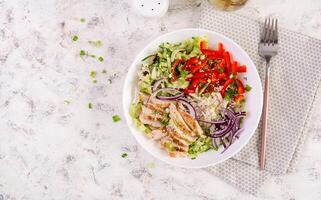 Fresh  salad  with grilled chicken breast, fillet and lettuce, daikon, red onions, cucumber and sesame. Healthy lunch menu. Diet food. Top view photo