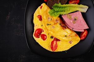 Omelette with tomatoes and cheese with bread and mortadella sausage. Top view photo