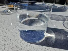 Focused view of a filled glass of water in sun reflection photo