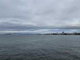 San Francisco skyline from golden gate bridge beach with a view of Alcatraz island in a cloudy day photo